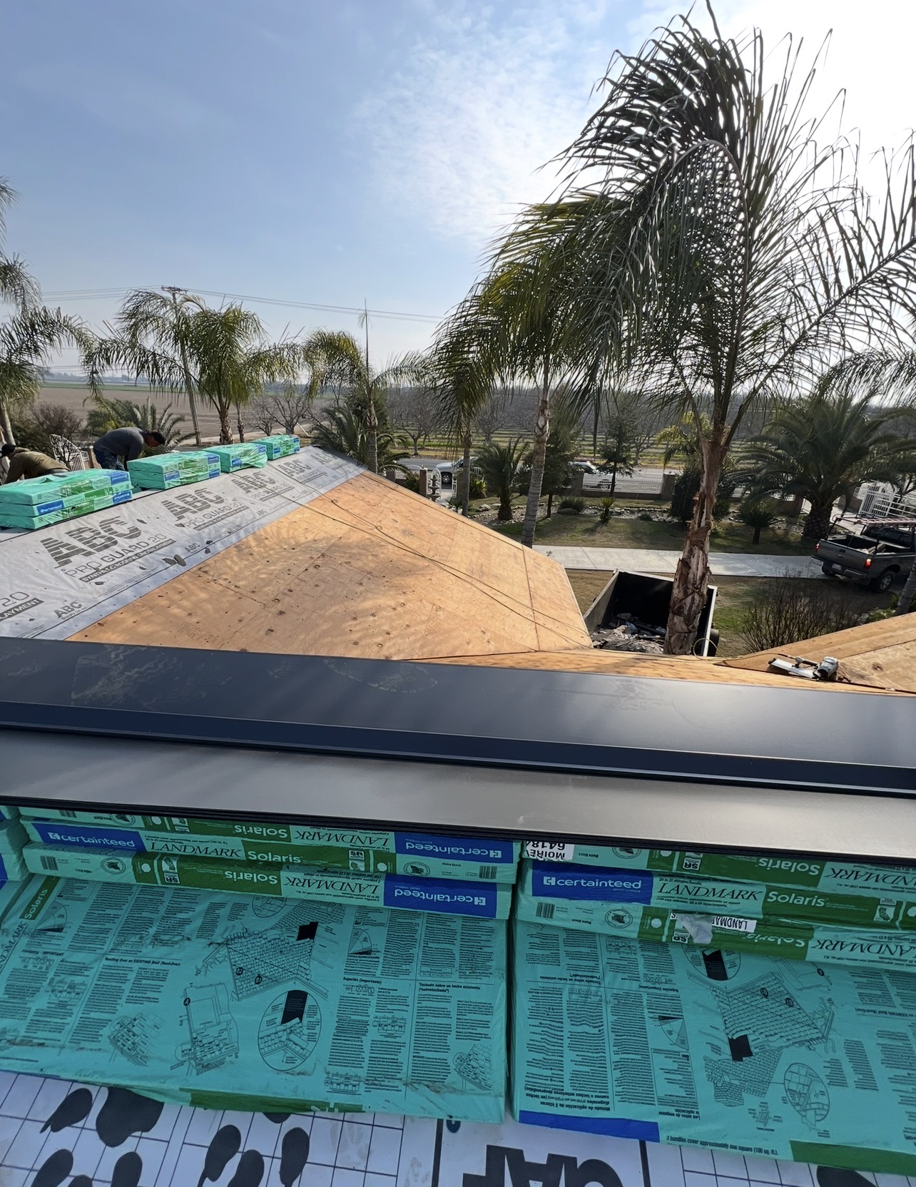Roof deck prep with underlayment and stacked shingle bundles