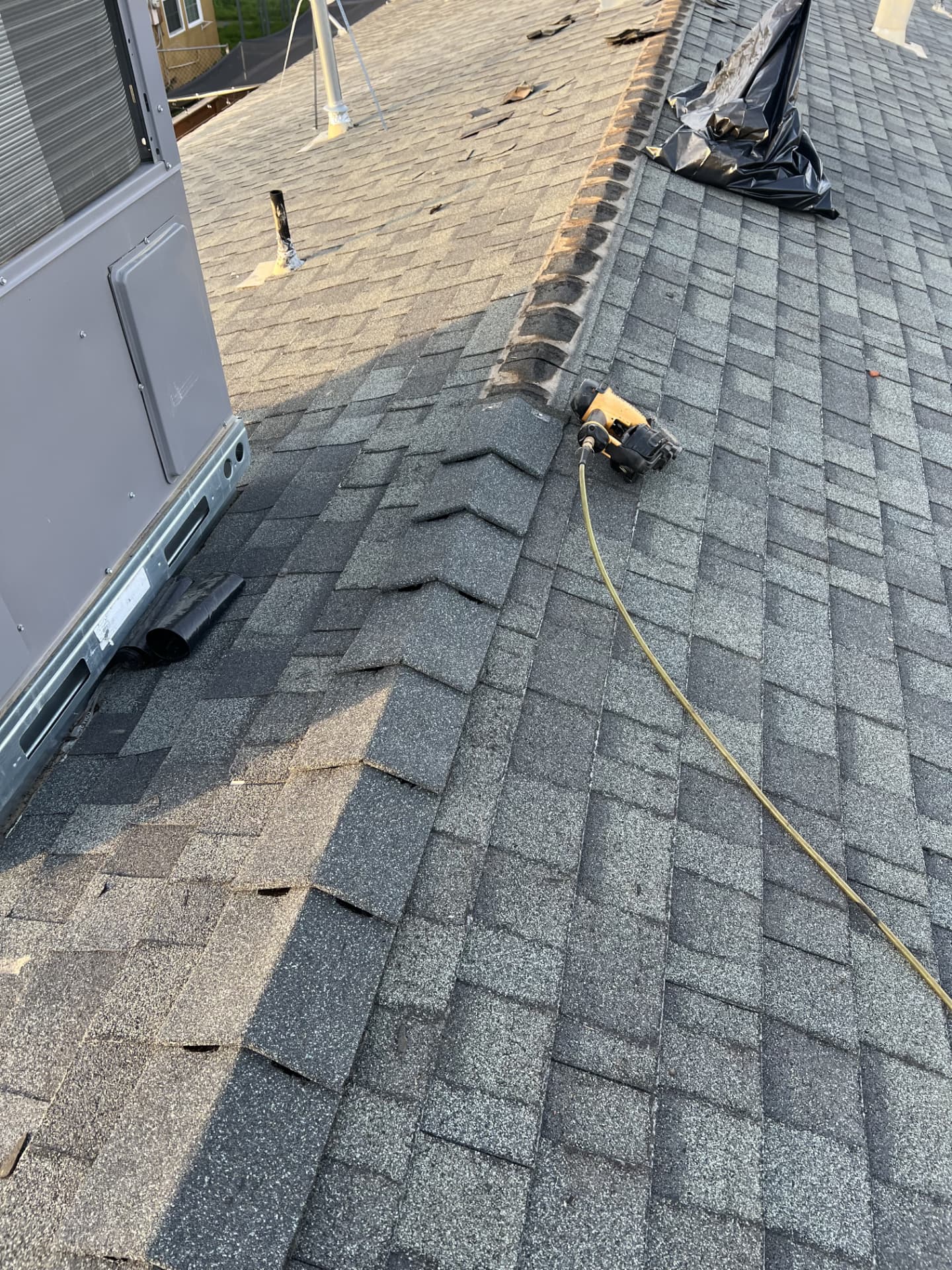 Ridge cap and shingle repair work in progress on a residential roof