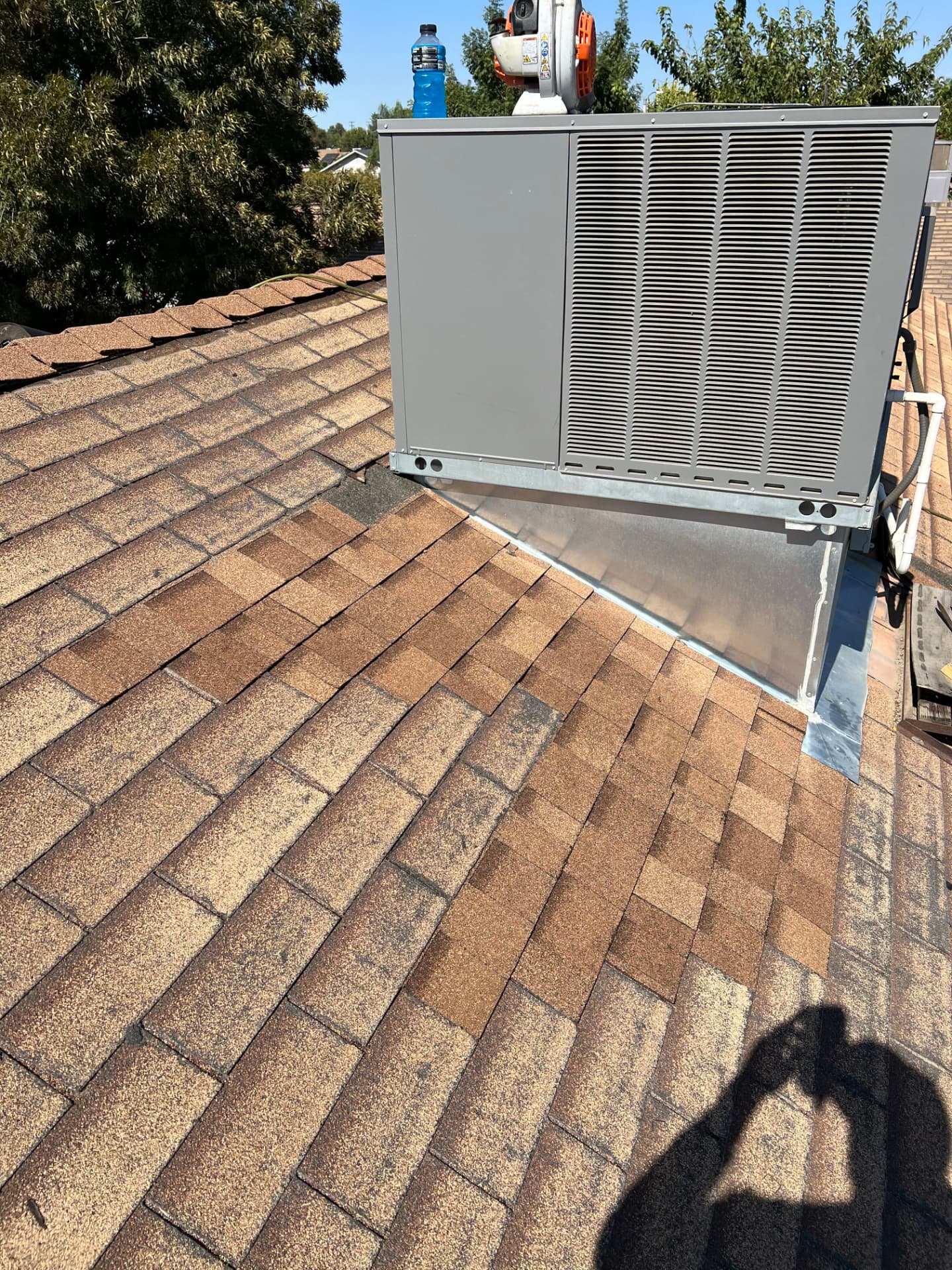 Rooftop HVAC unit service and flashing on a residential shingle roof