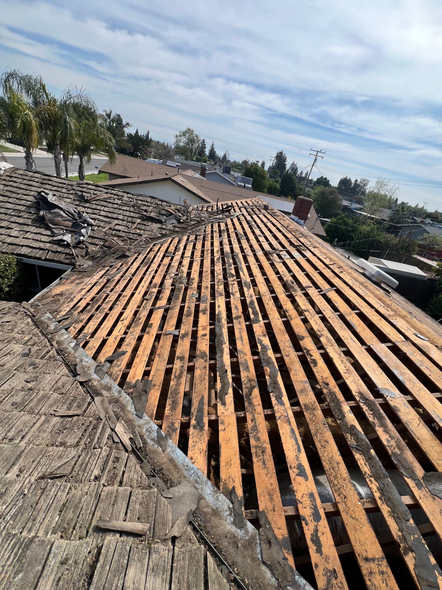 Tear-off of a deteriorated wood shake roof exposing skip sheathing