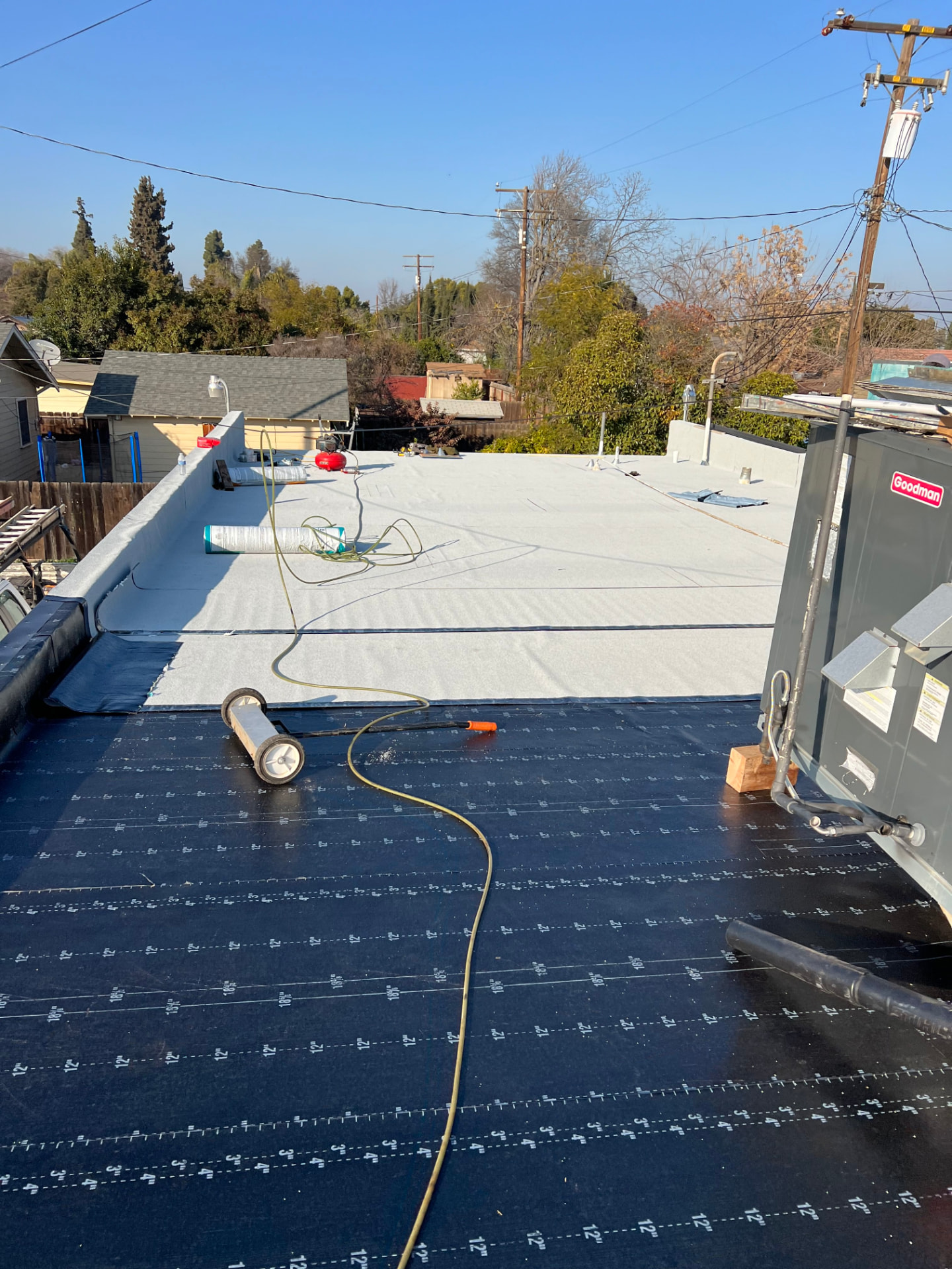 Commercial flat roof mid-installation with cap sheet and base layers