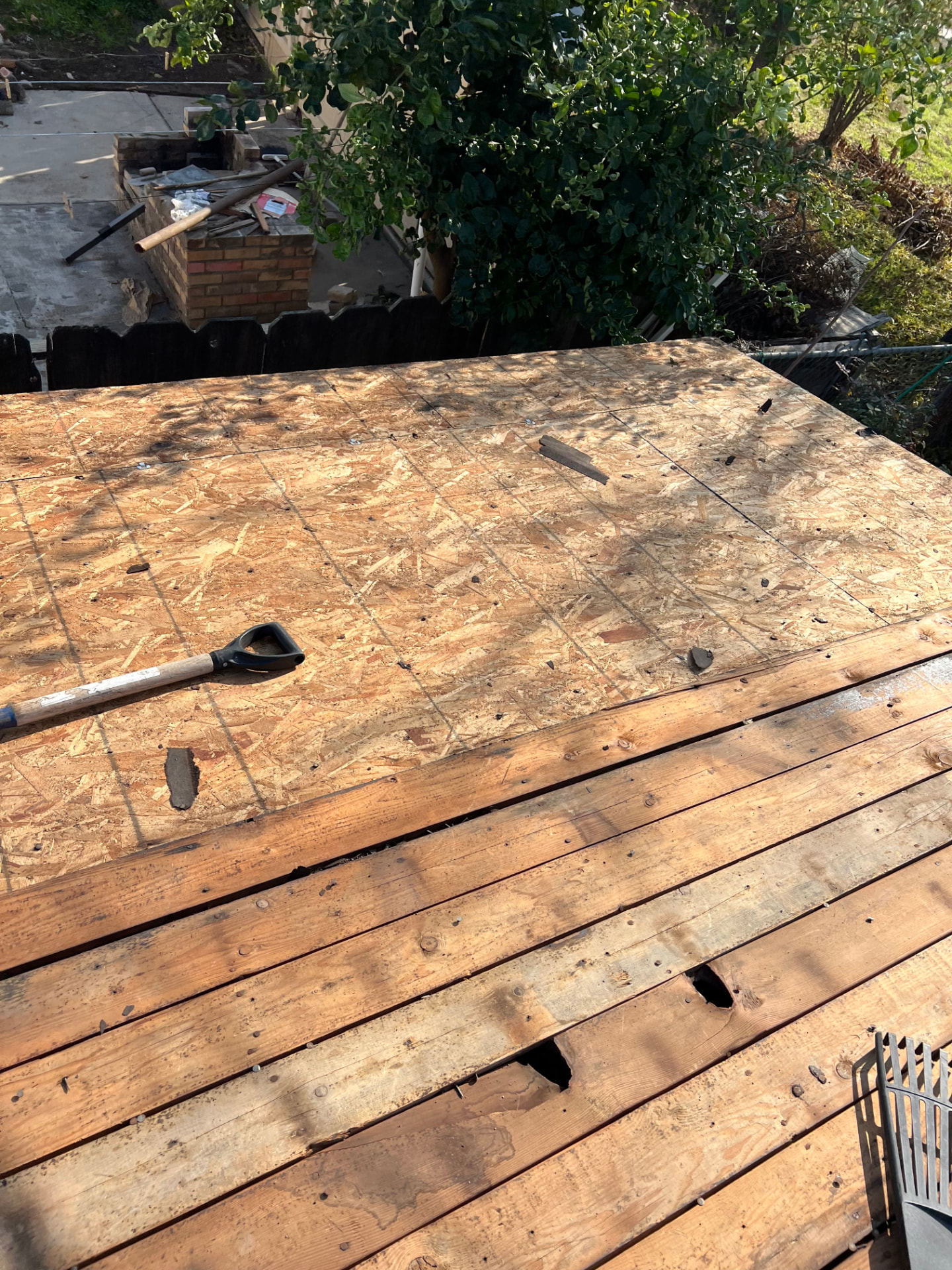 Residential roof tear-off exposing plywood deck ready for new materials