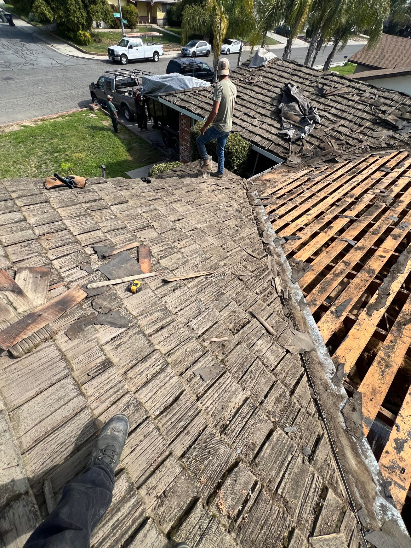 Crew removing an old worn wood shake roof