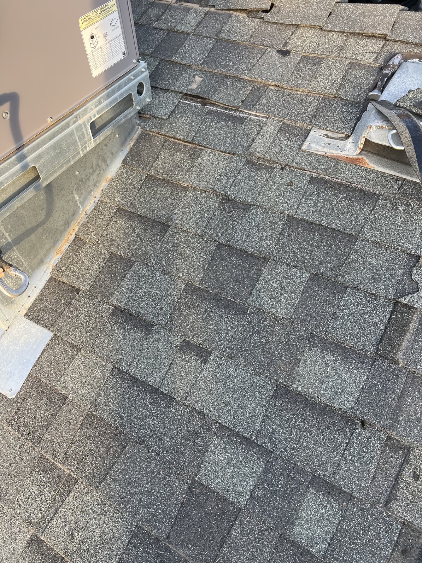 Shingle and flashing repair completed beside a rooftop unit