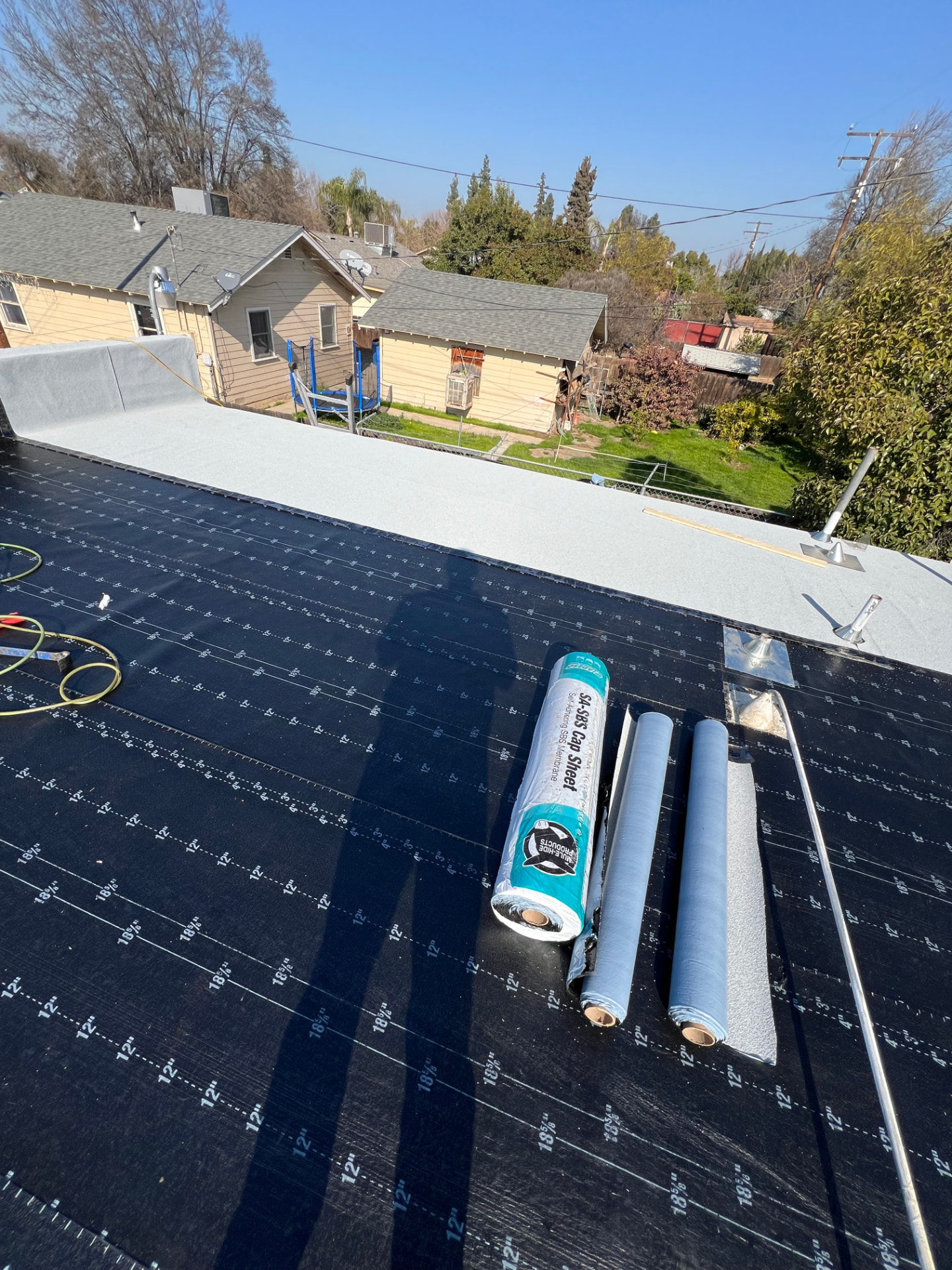 Commercial flat roof with SBS cap sheet rolls ready for installation